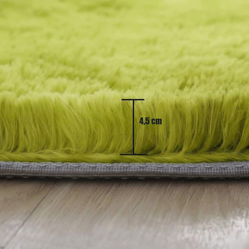 Détail de la hauteur du poil long de 4,5 cm, vue de la tranche du tapis rond vert sur parquet