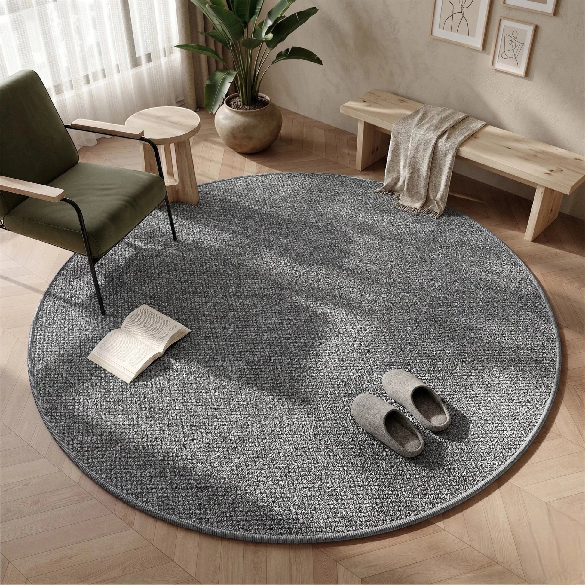 Tapis rond Wilton tissage plat gris dans une entrée lumineuse avec banquette en bois clair et fauteuil vert